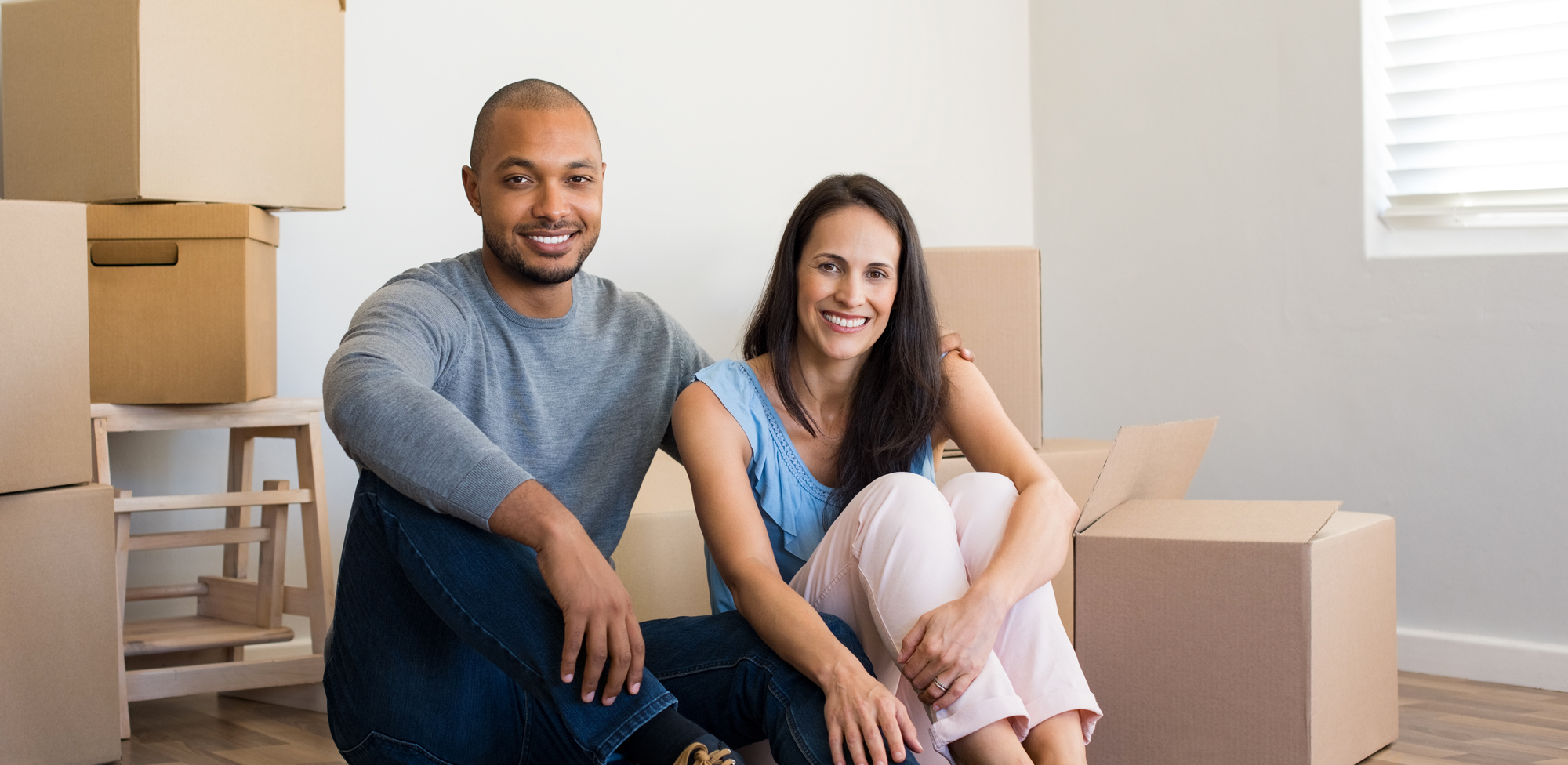 young couple sitting on floor around moving boxes