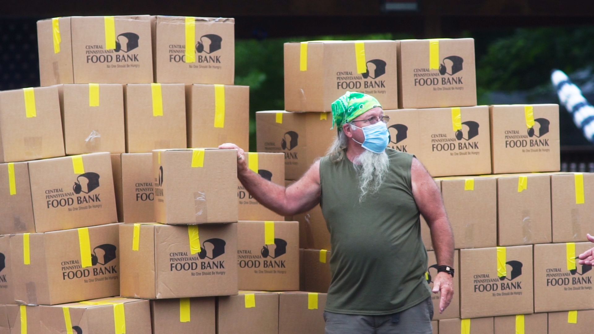 Photo of man in front of Central PA Food Bank boxes to be distributed