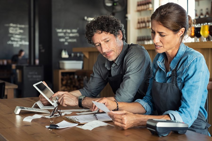 Man and woman looking at financial documents in a cafe