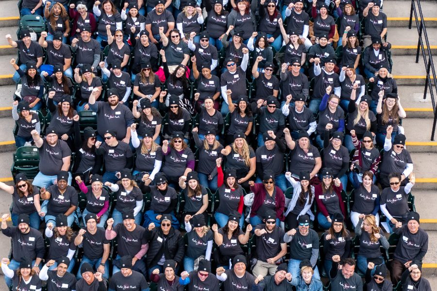 all traditions bank associates group photo with their hands in the air at an anniversary event