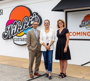 A man and two women smiling in front of Nikki's Custard storefront in Lancaster, PA.